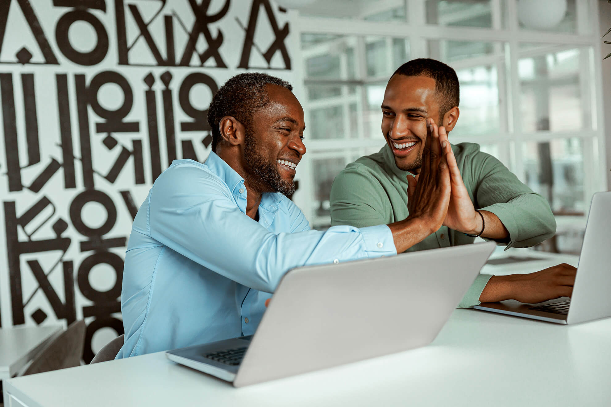 two business people at laptops completing their ethics training in the workplace