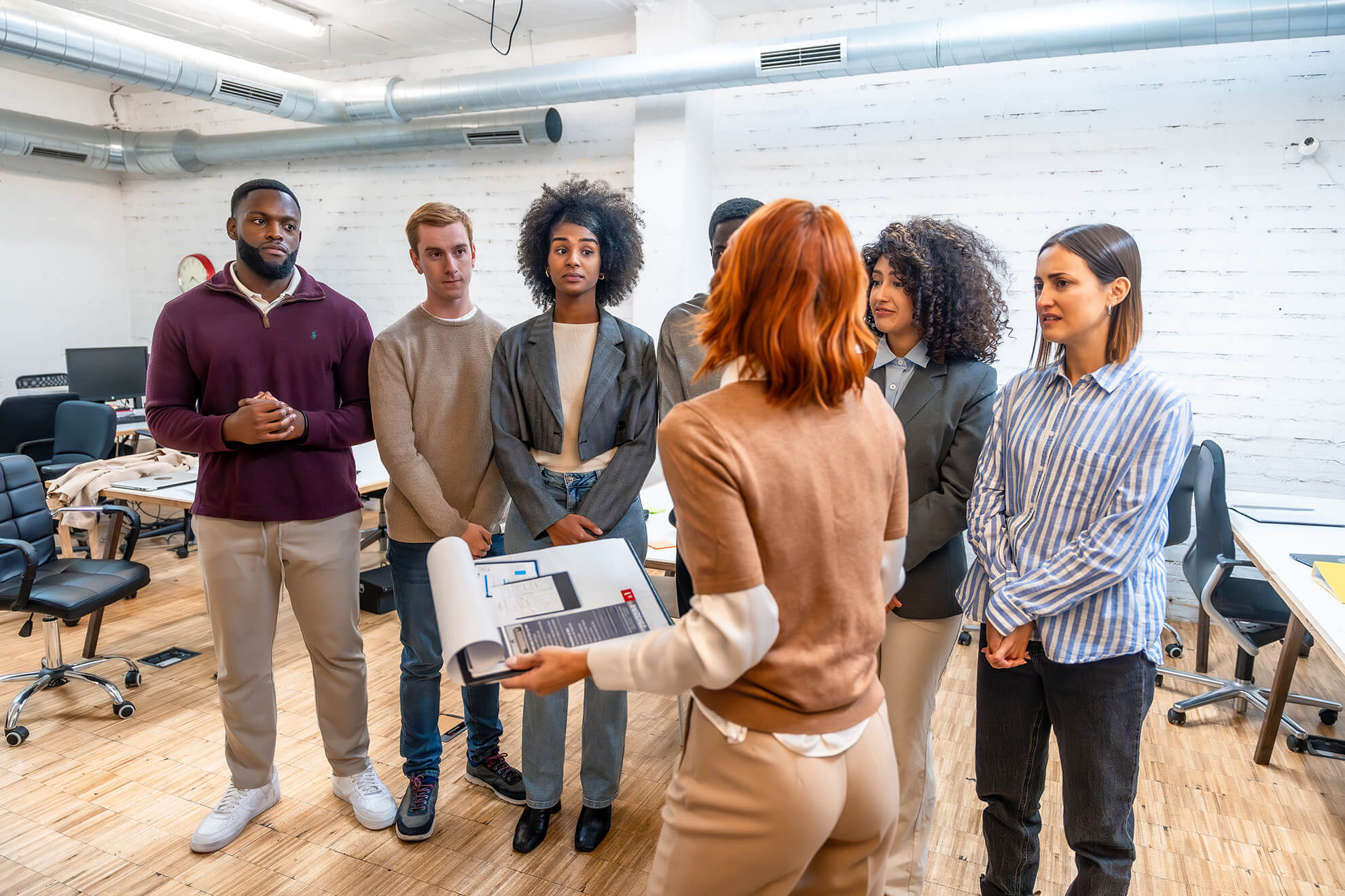 Female trainer standing and reviewing violence in the workplace training with diverse group of employees
